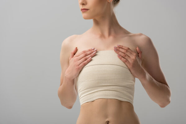 cropped view of woman with breast bandage