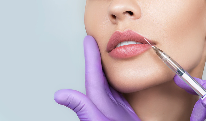 female lips, procedure lip augmentation. Syringe near womans mouth, injections for increase lips shape